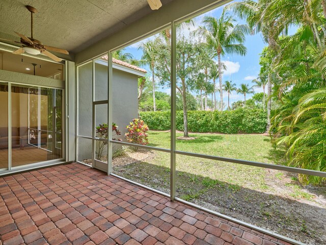 unfurnished sunroom with a ceiling fan