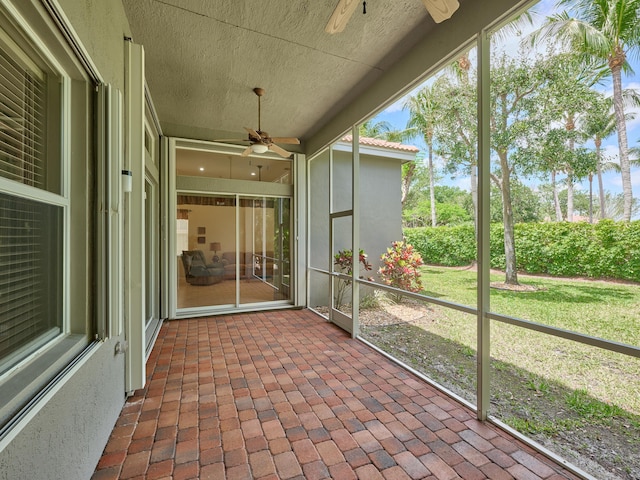 unfurnished sunroom with ceiling fan