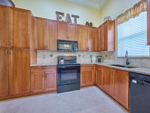 kitchen with crown molding, light stone countertops, a sink, backsplash, and black appliances