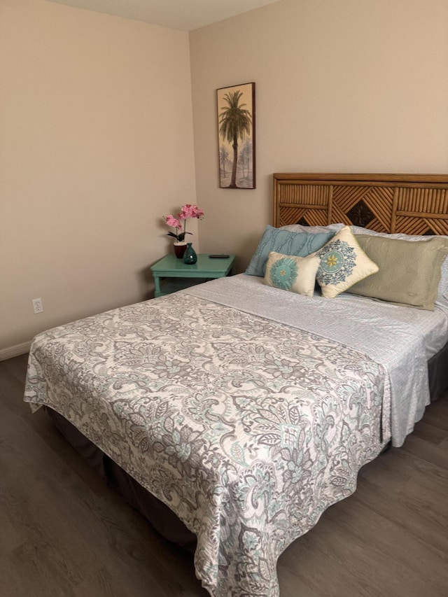 bedroom with baseboards and wood finished floors