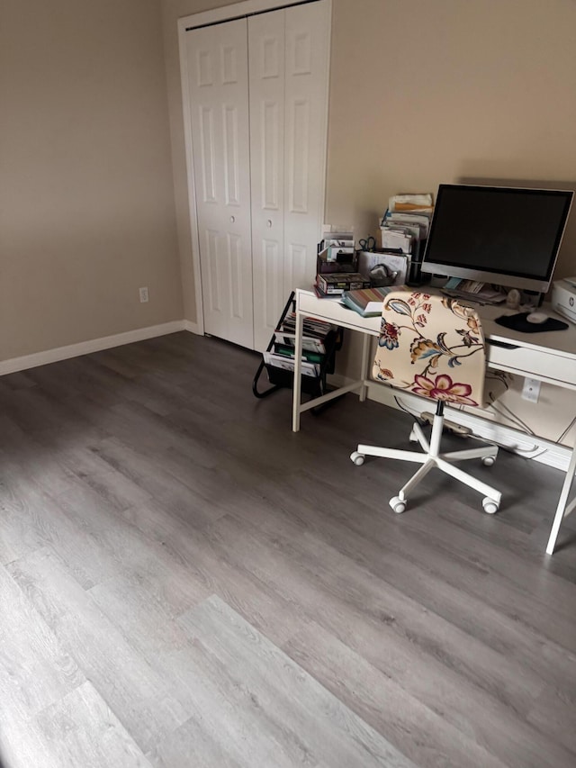 office area with baseboards and wood finished floors
