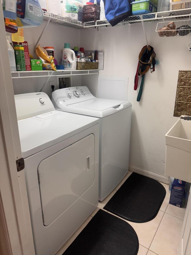 laundry room featuring washing machine and clothes dryer, laundry area, and tile patterned floors