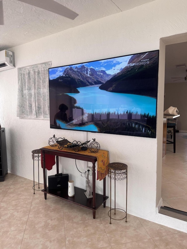 room details featuring an AC wall unit, a textured ceiling, and a textured wall
