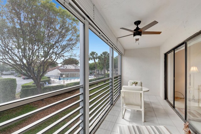 sunroom / solarium featuring a ceiling fan