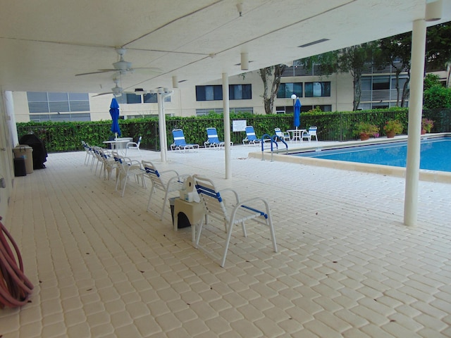 pool with ceiling fan, a patio area, and fence