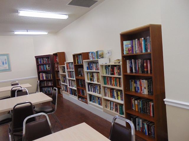 office featuring bookshelves, wood finished floors, and visible vents
