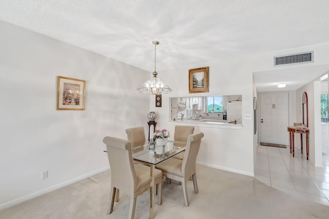 dining area featuring an inviting chandelier, baseboards, a textured ceiling, and visible vents