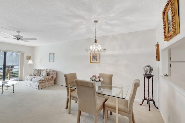 dining room featuring ceiling fan, a textured ceiling, and light colored carpet
