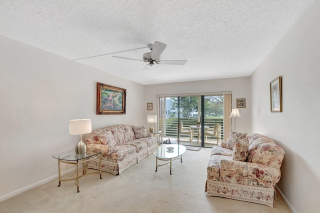 carpeted living area featuring a textured ceiling, ceiling fan, and baseboards