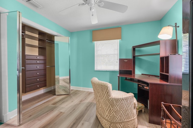 office featuring a ceiling fan, light wood-style flooring, and baseboards