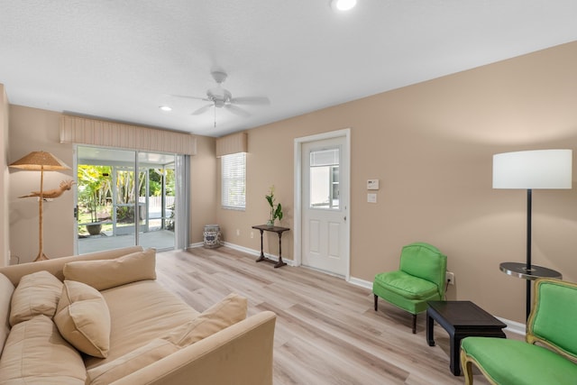 living area with ceiling fan, light wood finished floors, baseboards, and recessed lighting