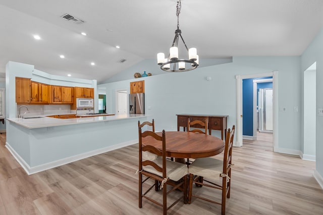 dining space with lofted ceiling, light wood finished floors, a chandelier, baseboards, and recessed lighting