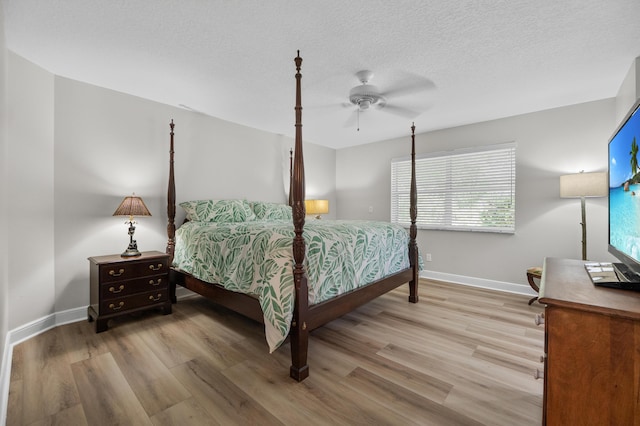 bedroom with wood finished floors, baseboards, a textured ceiling, and ceiling fan
