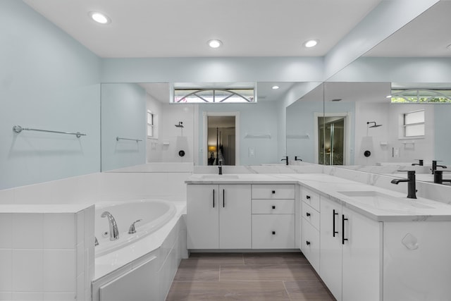 bathroom with a bath, a shower, double vanity, and recessed lighting