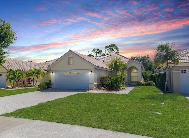 562 SW New Castle Cv, Port Saint Lucie, FL 34986 - view of front of house with stucco siding, a tiled roof, decorative driveway, a garage, and a front yard