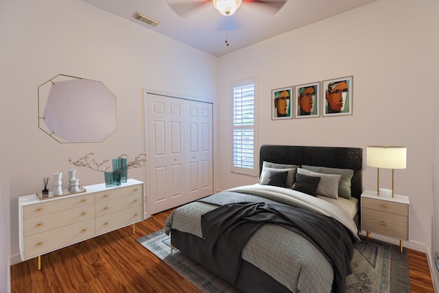 bedroom with dark wood-type flooring, a closet, and a ceiling fan