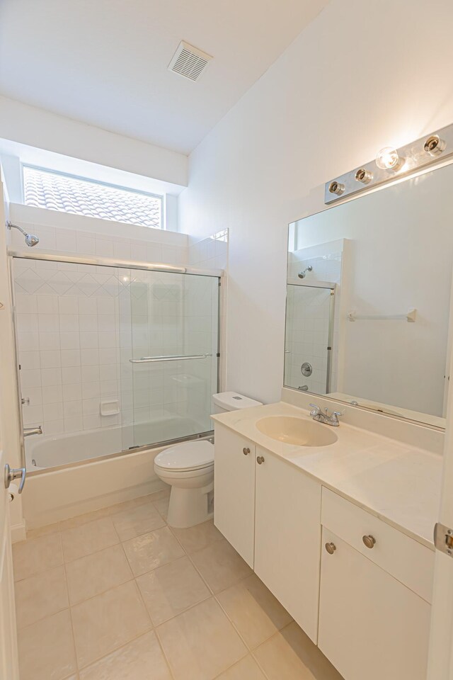 full bath featuring toilet, enclosed tub / shower combo, visible vents, tile patterned flooring, and vanity