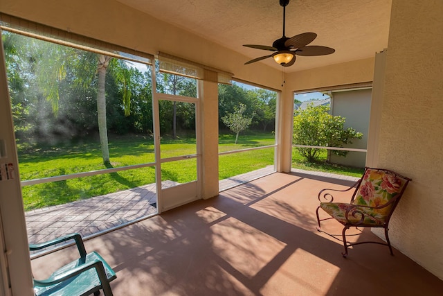 unfurnished sunroom with a ceiling fan