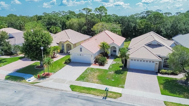 view of front facade with a tiled roof, a garage, and decorative driveway
