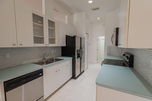 kitchen with appliances with stainless steel finishes, visible vents, decorative backsplash, and a sink