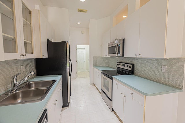 kitchen with decorative backsplash, stainless steel appliances, visible vents, and a sink