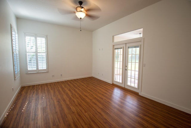 unfurnished room with baseboards, a ceiling fan, and dark wood finished floors
