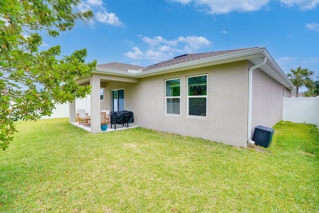 3625 Sapphire Hollow Way, Fort Pierce, FL 34981 - rear view of house with a patio, stucco siding, fence, and a lawn