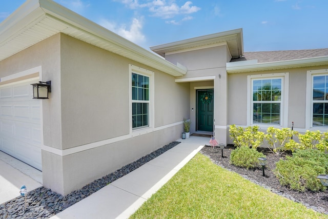 3625 Sapphire Hollow Way, Fort Pierce, FL 34981 - entrance to property featuring stucco siding, roof with shingles, and an attached garage
