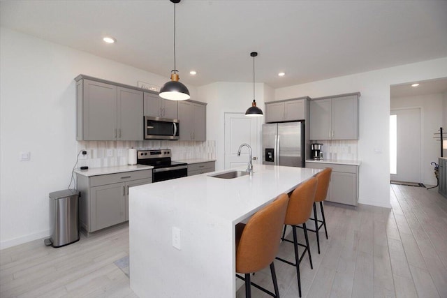 kitchen with a sink, gray cabinets, and stainless steel appliances