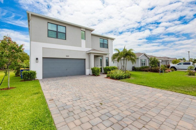 view of front of property featuring stucco siding, decorative driveway, a front lawn, and a garage