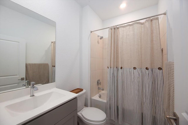 bathroom with vanity, shower / bath combination with curtain, and toilet