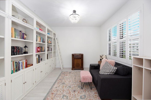 sitting room featuring baseboards, a chandelier, and light wood-style flooring