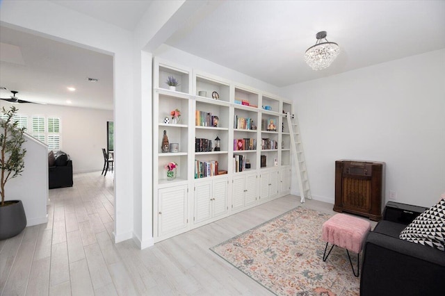 sitting room featuring baseboards, wood finished floors, a chandelier, and visible vents