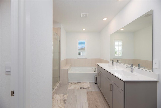 bathroom featuring recessed lighting, a sink, a bath, and wood finished floors