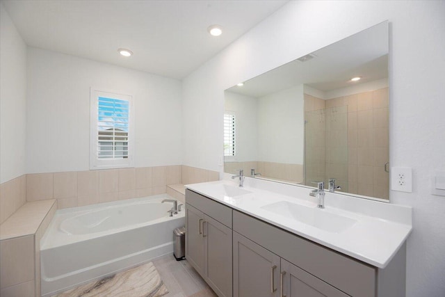 full bath with a healthy amount of sunlight, a sink, and a bath