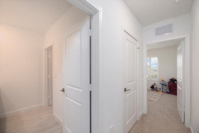 corridor featuring baseboards and visible vents