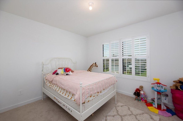 bedroom featuring baseboards and carpet