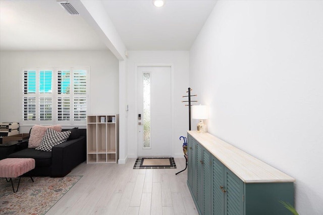 foyer entrance with visible vents, light wood finished floors, and baseboards