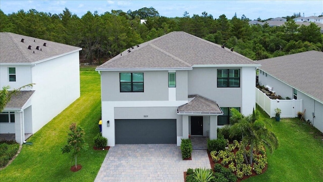 view of front of house with a shingled roof, a front lawn, a garage, stucco siding, and driveway
