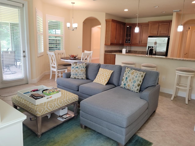 living area with arched walkways, baseboards, recessed lighting, and light tile patterned flooring