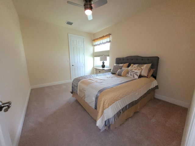 carpeted bedroom with visible vents, baseboards, and ceiling fan