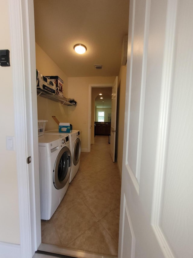 washroom with light tile patterned floors, visible vents, laundry area, and washer and clothes dryer