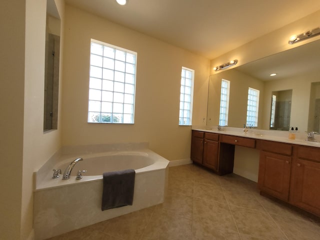 bathroom with a healthy amount of sunlight, tile patterned floors, double vanity, and a bath