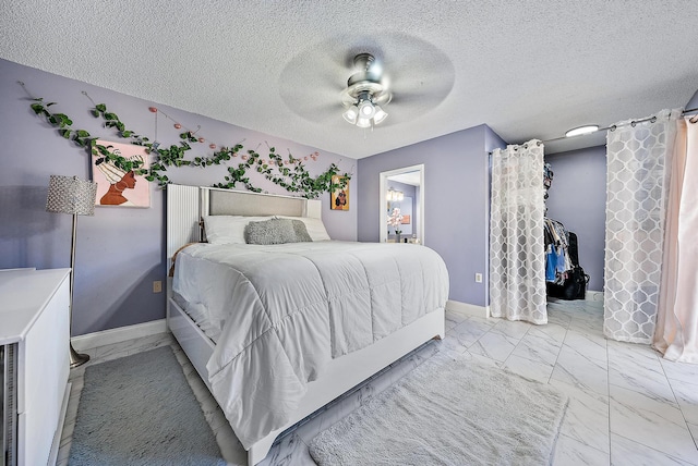 bedroom with baseboards, a ceiling fan, a textured ceiling, and marble finish floor
