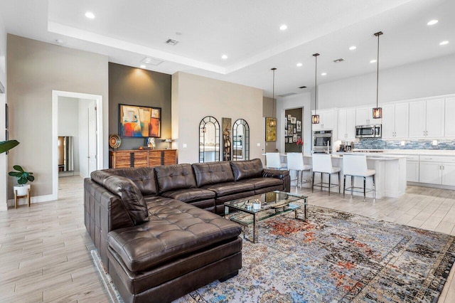 living area featuring recessed lighting, light wood-style floors, and visible vents