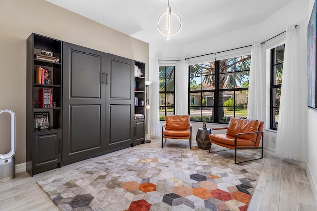 sitting room with baseboards and light wood finished floors