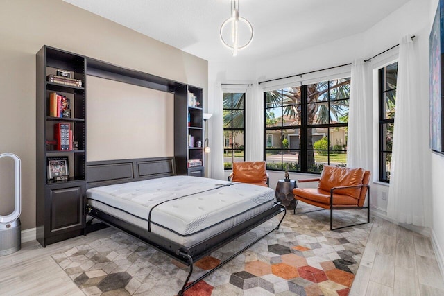 bedroom with baseboards and light wood finished floors
