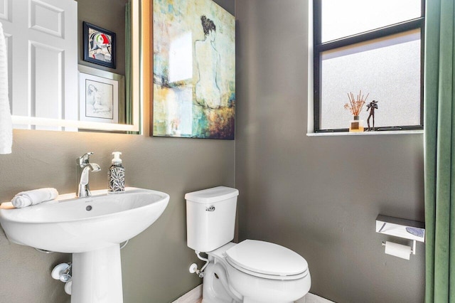 half bath with toilet and a sink