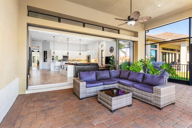 living area with a ceiling fan and brick floor