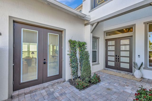 view of exterior entry featuring stucco siding and french doors